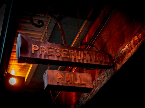 A dimly lit sign reading "Preservation Hall" hangs, creating a vintage and historic ambiance.