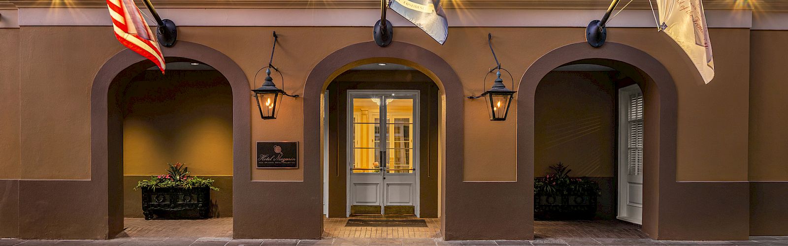 The main entrance of a building with archways, lanterns, and flags